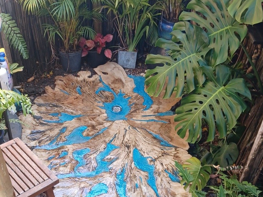 Custom resin and wood floor detail near a pool shower